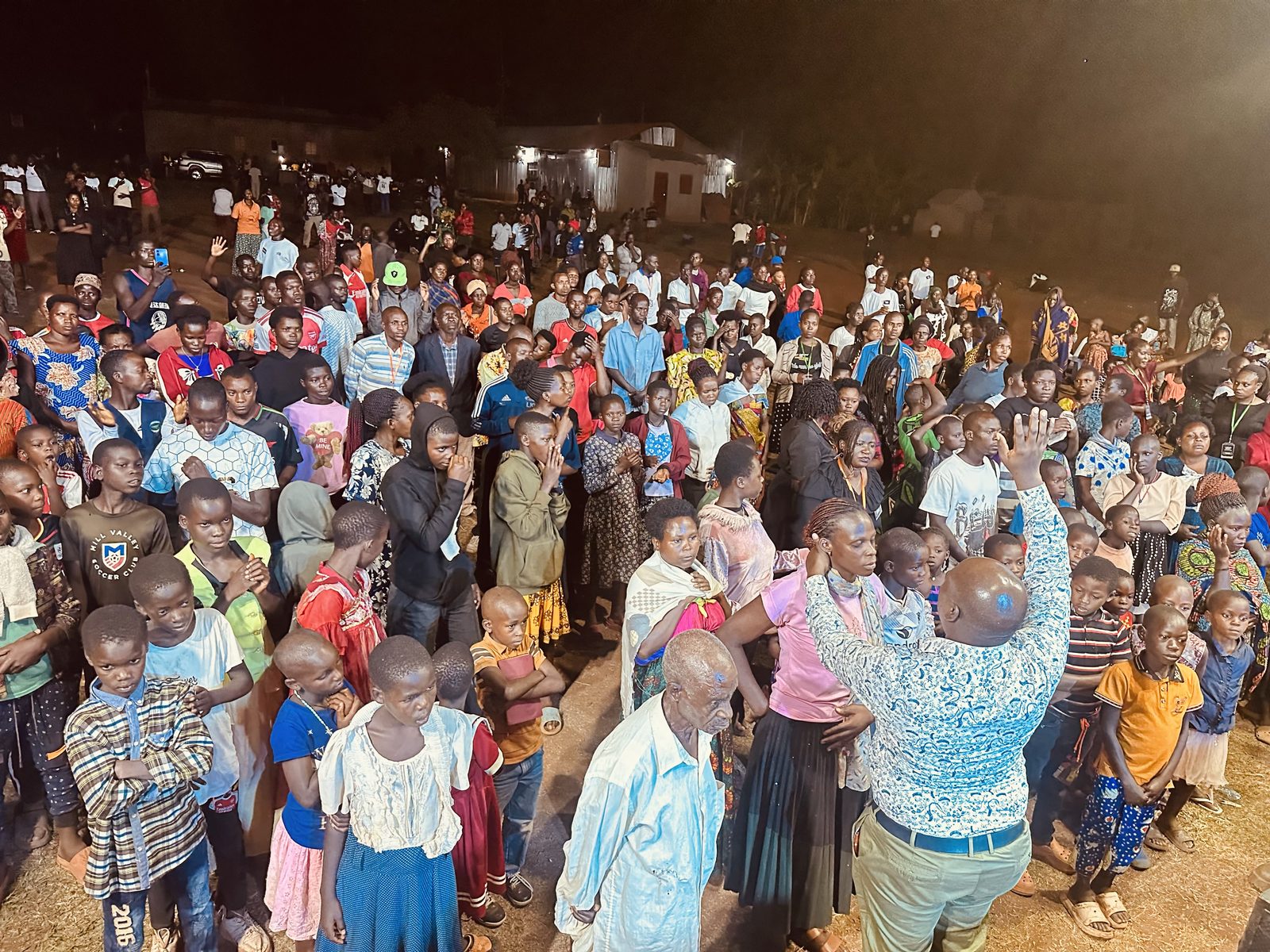The whole community turns out, hands raised in worship.